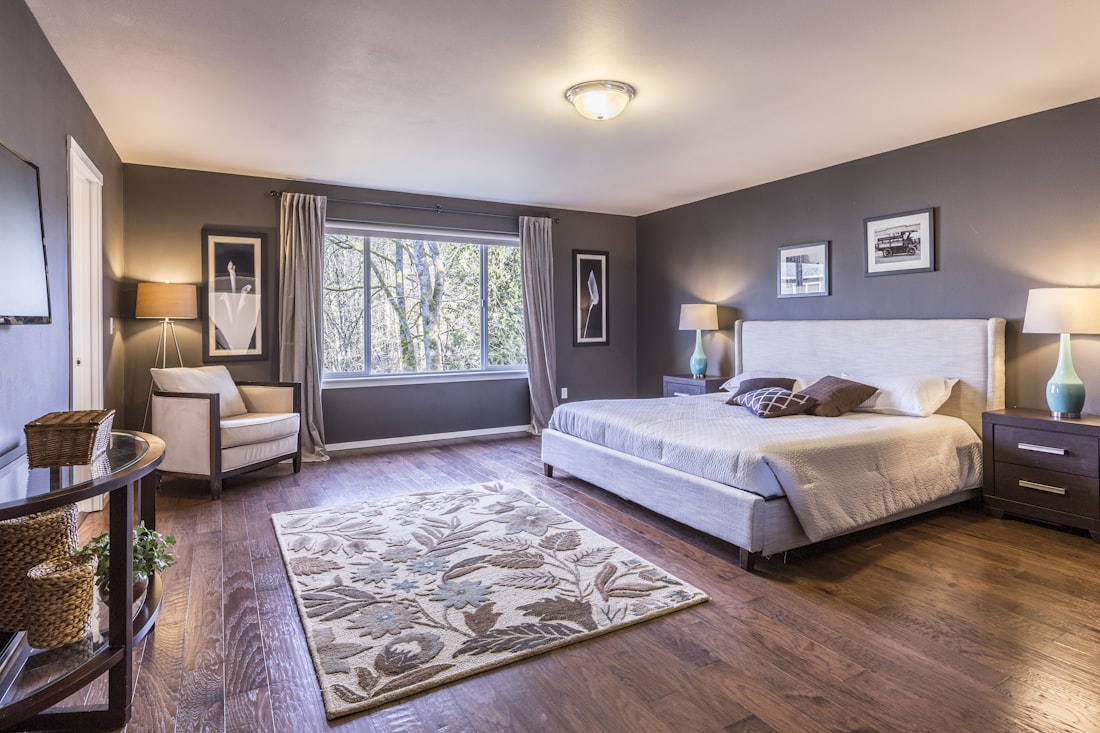 A spacious warm bedroom with an upholstered bed